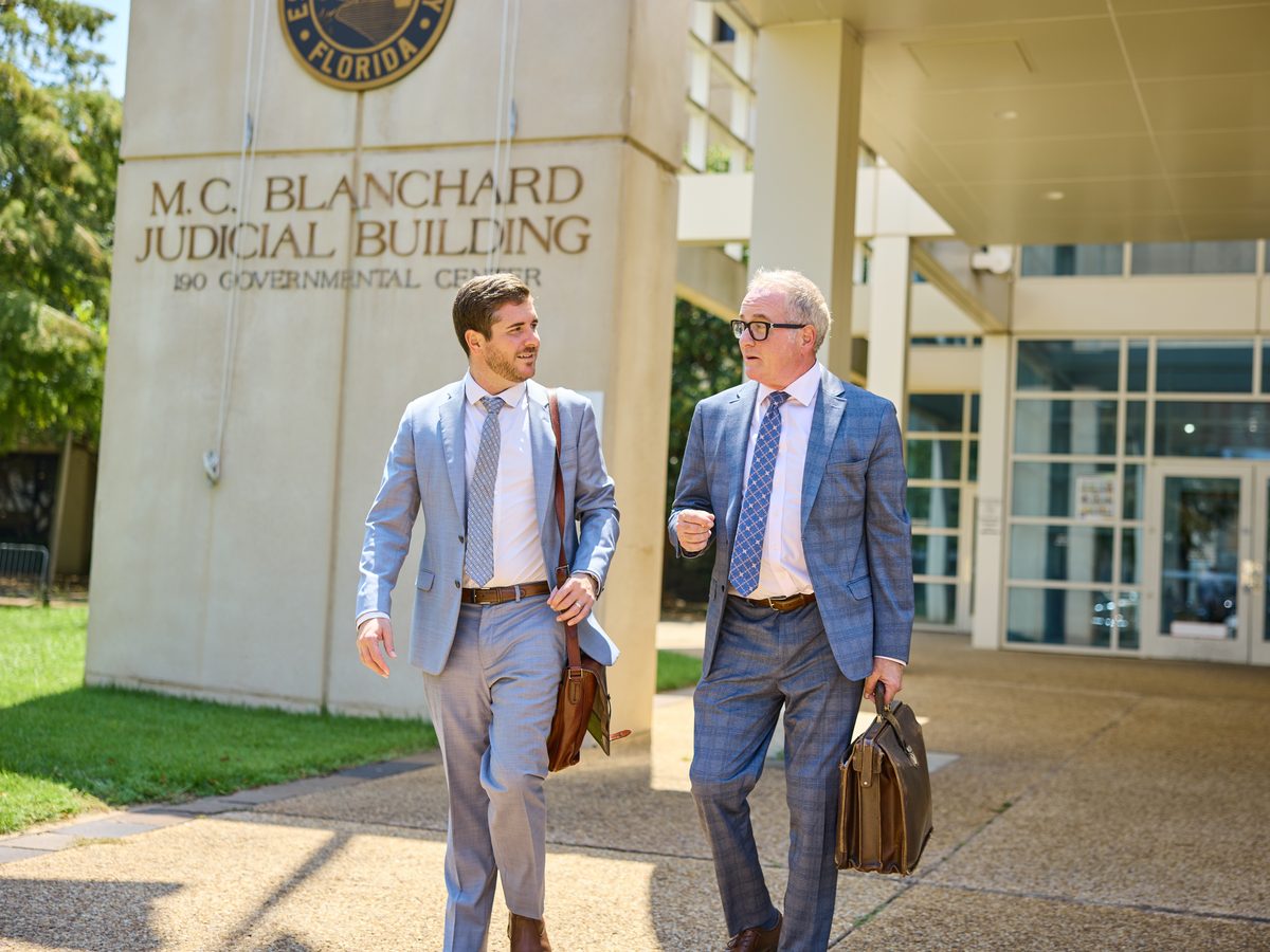 James and Mason Barnes walking out of the M.C. Blanchard Judicial Building in downtown Pensacola with their briefcases